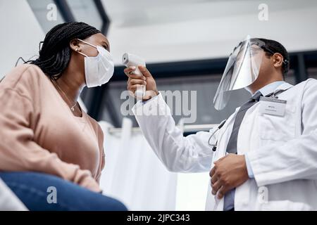 Dépistage Covid avec un médecin mesurant la température d'un patient à l'aide d'un thermomètre infrarouge lors d'un rendez-vous ou d'un contrôle. Femme testée Banque D'Images
