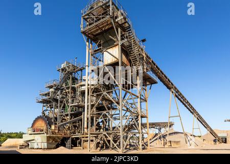 Vue panoramique construction en métal lourd usine de gravier à ciel ouvert carrière de sable grosse machine à rotor rouillé excavation et broyage sur ciel bleu Banque D'Images