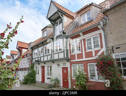 Maisons historiques à colombages dans la vieille ville de Flensburg, en Allemagne, sur une ruelle étroite de pavés avec des fleurs sur les façades, attraction touristique, se Banque D'Images