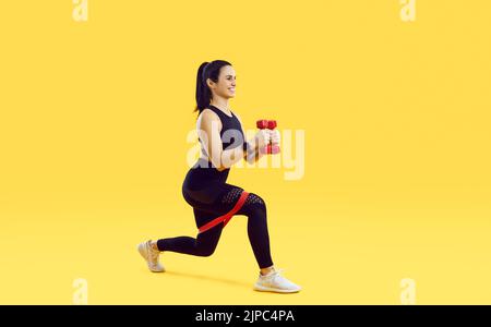 Entraînement de femme motivée et tonifiée sur fond jaune Banque D'Images