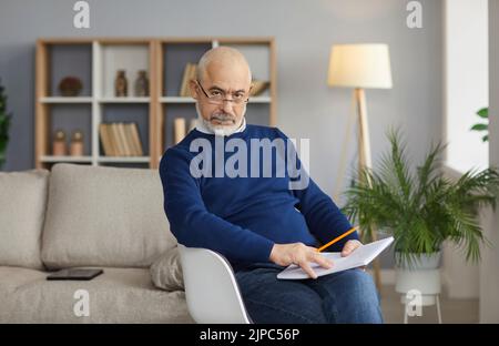 Portrait d'un vieil homme sérieux posé au bureau Banque D'Images