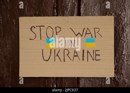 Des panneaux de papier avec des slogans stoppent la guerre en Ukraine accrochent sur la porte marron de la maison, la guerre en Ukraine 2022 Banque D'Images