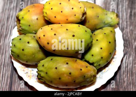 Une assiette avec pile de fruits frais de poire épineuse isolée sur fond de bois, foyer sélectif, Opuntia, communément appelé poire épineuse, figuier de Barbarie, thon Banque D'Images