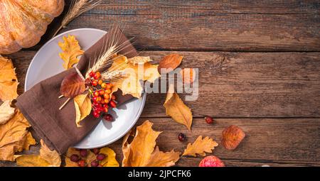 Arrière-plan d'automne avec couverts et feuilles d'automne sur un fond en bois. Banque D'Images