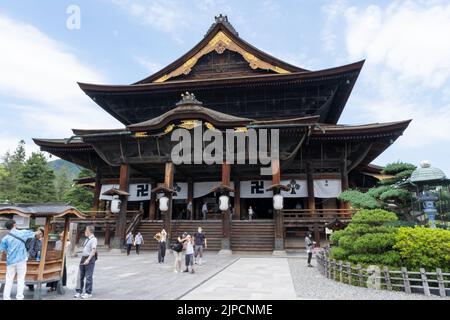 Le bâtiment principal du temple de Zenko-Ji en été. Un temple bouddhiste construit en bois. Les visiteurs et les touristes prient au temple pendant le COVID Banque D'Images