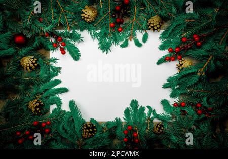 Arrière-plan des fêtes de Noël avec décorations de fête. Composition de Noël. Cadre fait de cadeaux de noël, branches de pin foncé sur fond blanc. Banque D'Images