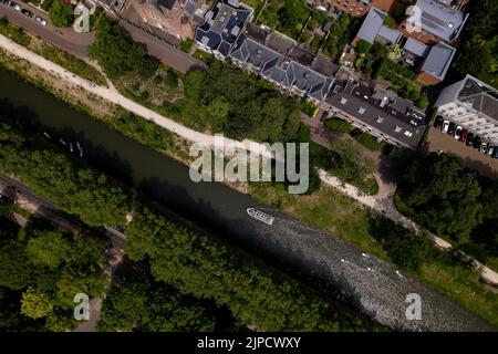 Vue aérienne de haut en bas sur le canal dans la ville médiévale hollandaise d'Utrecht avec des bateaux de loisirs et touristiques vus d'en haut le long de la promenade du centre-ville Banque D'Images