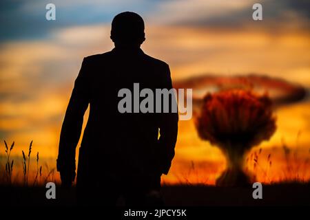 Le concept d'une frappe nucléaire. Silhouette d'un homme en costume à l'observation d'une explosion atomique. Un homme politique qui a lancé une guerre nucléaire. Fin du monde Banque D'Images