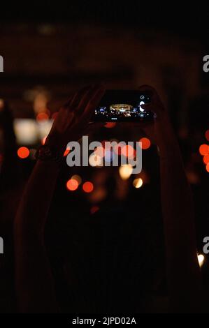 Quelqu'un prenant une photo avec un téléphone pendant la vénération de la Sainte Croix après la Messe pendant Mladifest (Festival de la Jeunesse) à Medjugorje. Banque D'Images