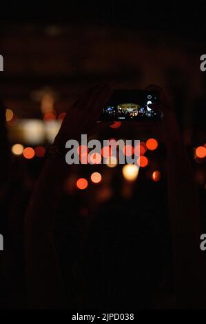 Quelqu'un prenant une photo avec un téléphone pendant la vénération de la Sainte Croix après la Messe pendant Mladifest (Festival de la Jeunesse) à Medjugorje. Banque D'Images