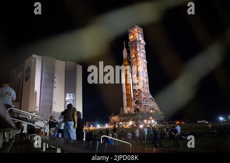 Des invités et des employés de la NASA regardent la fusée SLS (Space Launch System) de la NASA avec l'engin spatial Orion à bord, qui sort du bâtiment d'assemblage de véhicules pour lancer le panneau 39B, mardi, 16 août 2022, au Kennedy Space Center de la NASA en Floride. L’essai en vol Artemis I de la NASA est le premier essai intégré des systèmes d’exploration spatiale profonde de l’agence : l’engin spatial Orion, la fusée SLS et les systèmes terrestres auxiliaires. Le lancement de l'essai en vol non crewed n'est pas prévu avant 29 août 2022. Photo de Joel Kowsky/NASA via CNP/ABACAPRESS.COM Banque D'Images