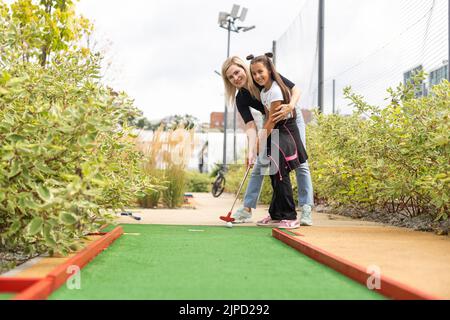 petite fille et mère jouant au mini-golf Banque D'Images