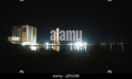 Floride. ÉTATS-UNIS, 16/08/2022, la fusée SLS (Space Launch System) de la NASA à bord de l'engin spatial Orion est vue au-dessus du lanceur mobile alors qu'elle sort du bâtiment d'assemblage de véhicules pour lancer le Pad 39B, le mardi 16 août 2022, au Kennedy Space Center de la NASA en Floride. La mission Artemis I de la NASA est le premier test intégré des systèmes d'exploration spatiale profonde de l'agence : l'engin spatial Orion, la fusée SLS et les systèmes de soutien au sol. Le lancement de l'essai en vol sans équipage est prévu au plus tard le 29 août 2022. Crédit obligatoire : Joel Kowsky/NASA via CNP/MediaPunch Banque D'Images