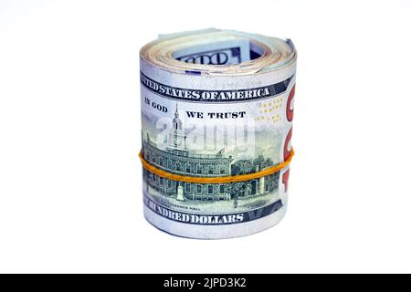 Lot de rouleaux de dollars isolés sur fond blanc, pile de cent dollars US cash billets roulés avec des bandes de caoutchouc featur Banque D'Images