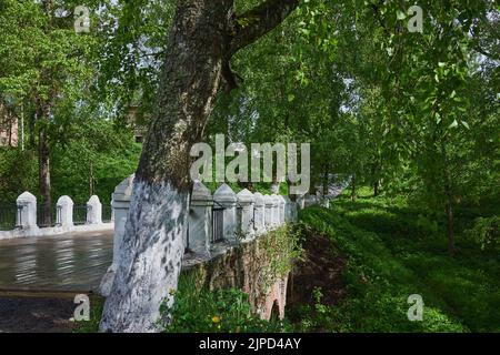 Un vieux pont de briques avec des piliers blancs parmi les arbres verts. Pont suspendu de Leontief à Tutayev, ancien Romanov-Borisoglebsk. Banque D'Images