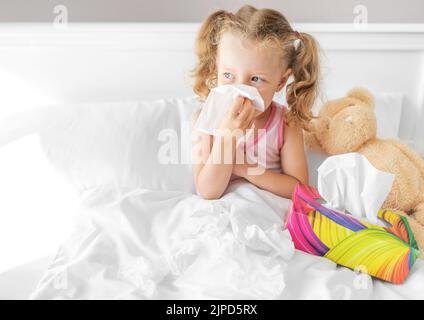 L'enfant lui-même souffle le snot dans une serviette. Banque D'Images