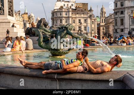 Les jeunes se refroidisse près des fontaines d'eau de Trafalgar Square pendant la journée la plus chaude jamais enregistrée dans la capitale, Londres, Royaume-Uni. Banque D'Images