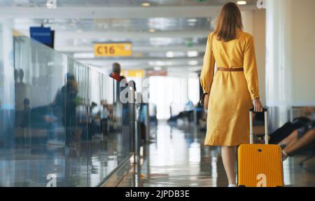 Femme marchant dans le terminal de l'aéroport. Vue arrière. Banque D'Images