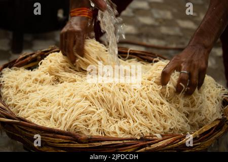 Chinois Schezwan également appelé Szechwan Veg Hakka Noodles Chowmin ou Indian Veg Chow Mein être rincé dans l'eau dans le panier de bambou. Dhaba style Bul Banque D'Images