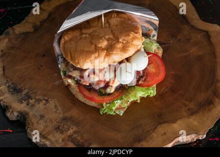 gros plan d'un hamburger colombien, dans un stand de restauration rapide de rue. pain, laitue, tomate, viande de hamburger, fromage mozzarella, bacon Banque D'Images