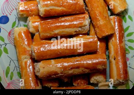 Un gros plan de la pâtisserie arabe de biscuits en forme de doigts farcis et remplis de malban ou de créamerie, la pâte enveloppée de bonbons cuits au four est Banque D'Images