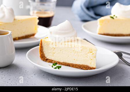 Cheesecake New-yorkais classique avec une cuillerée de crème fouettée Banque D'Images