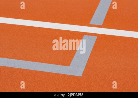 Court de tennis extérieur orange inhabituel avec lignes blanches et lignes de pickleball gris clair combinées. Banque D'Images