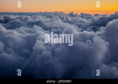 Vue depuis une fenêtre d'avion de nuages pendant le coucher du soleil. Banque D'Images
