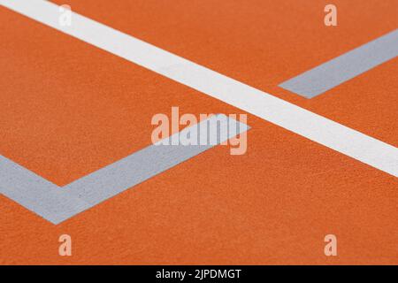 Court de tennis extérieur orange inhabituel avec lignes blanches et lignes de pickleball gris clair combinées. Banque D'Images