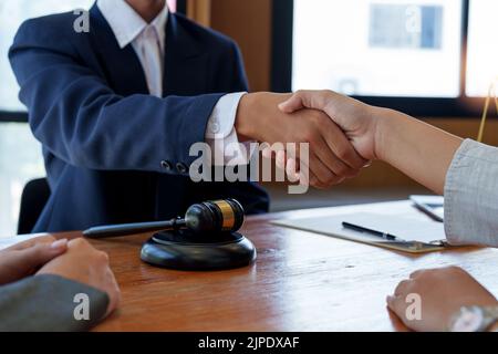 Homme d'affaires se serrant la main pour conclure un accord avec ses avocats partenaires ou avocats discutant d'un contrat. Banque D'Images