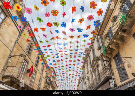 (C) Denis TRASFI / MAXPPP - à Sarlat-la-Canéda le 16-08-2022 - plafond de fleur colorée dans la rue principale du marché (rue de la République) dans l Banque D'Images