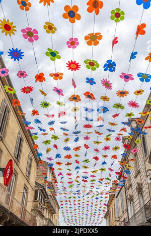 (C) Denis TRASFI / MAXPPP - à Sarlat-la-Canéda le 16-08-2022 -plafond de fleur colorée dans la rue principale du marché (rue de la République) dans la Banque D'Images