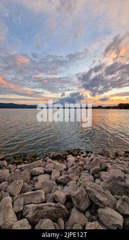 Coucher de soleil sur le lac de Constance avec une ambiance colorée de nuages en pierres sur la rive du lac Banque D'Images