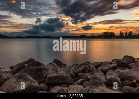 Pierres sur la rive du lac Sunset Lake Constance avec nuages dans le ciel Banque D'Images