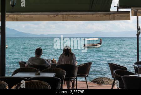 Couple touristique surplombant le lac Ohrid depuis une terrasse, Macédoine du Nord. Banque D'Images