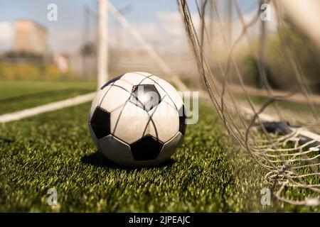 ballon de football blanc et noir sur fond d'herbe verte et de stade. idée de paris sportifs. Banque D'Images