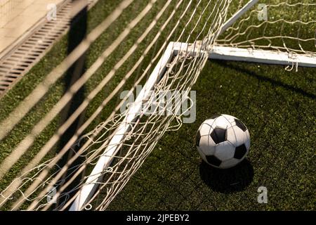 ballon de football blanc et noir sur fond d'herbe verte et de stade. idée de paris sportifs. Banque D'Images