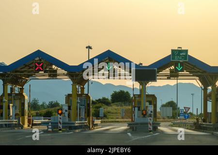 Le péage du point de contrôle de l'autoroute payant indique la bonne direction sur l'autoroute. Les panneaux verts de l'autoroute permettent de rouler contre les collines au coucher du soleil Banque D'Images