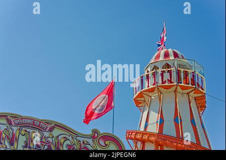 Regardant vers le haut un tour helter-skelter à la foire avec un ciel bleu en arrière-plan à Skegness Banque D'Images