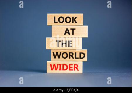 Regardez le symbole du monde entier. Les mots de concept regardent le monde plus large sur des blocs de bois sur un beau fond gris de table. Business et look Banque D'Images