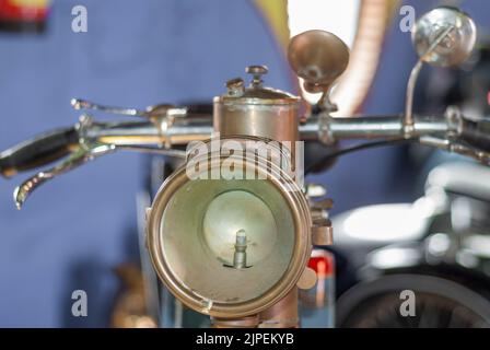 Ampoule dans le phare de la vieille moto classique avec des rétroviseurs extérieurs métalliques sur le guidon Banque D'Images