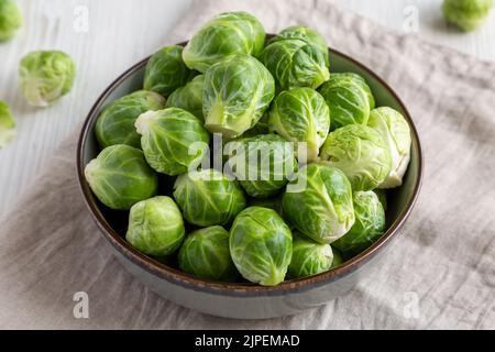 Pousses de Brussel biologique brut dans un bol, vue latérale. Banque D'Images