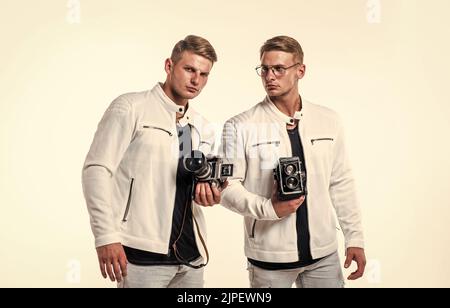 les deux frères hommes se ressemblent utilisent un appareil photo vintage pour photographier Banque D'Images