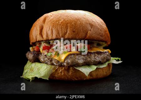 Hamburger avec bœuf et légumes chauds sur fond noir Banque D'Images