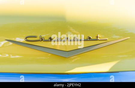 Loveland, CO - 9 juillet, 2022 : emblème du capot avant d'un bel Air de Chevrolet jaune au salon de l'auto classique de Loveland Banque D'Images