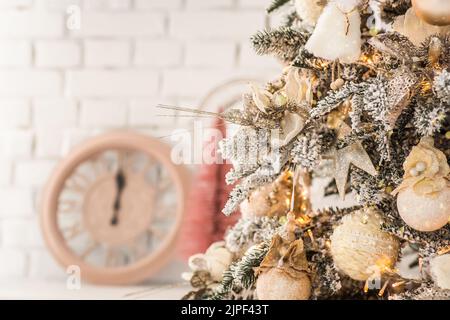 Un ange de Noël sur les branches d'un arbre de Noël sur le fond d'une horloge montrant 12.Célébration de la Saint-Sylvestre 2022 Banque D'Images