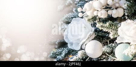 Gros plan des boules sur l'arbre de noël.Concept de la nouvelle année.Roses blanches dans le d cor de l'arbre de Noël. Fond avec décorations de Noël.Copier l'espace Banque D'Images