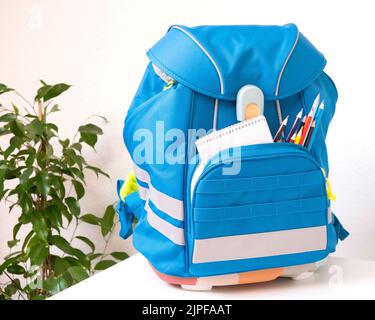 Sac à dos classique de couleur pour l'école avec fournitures. Préparation pour l'école. Retour à l'école Banque D'Images