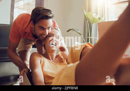 Couple amusant se déplaçant dans la première maison ensemble, s'amusant et appréciant leur liberté. Jeunes jeunes jeunes jeunes jeunes jeunes mariés qui apprécient leur nouvelle maison, se berner et se sentir Banque D'Images