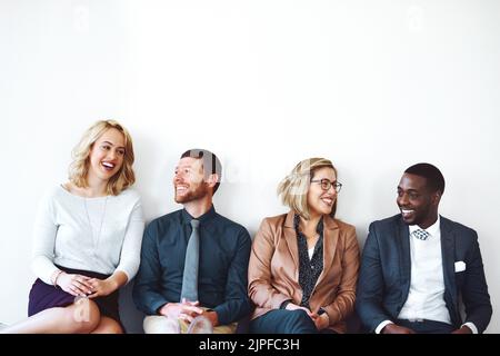 Partager nos histoires de succès. Un groupe d'entrepreneurs assis sur un fond blanc. Banque D'Images